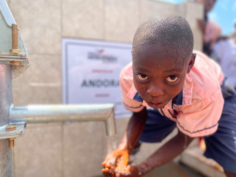 A pupil collecting water from a newly constructed borehole